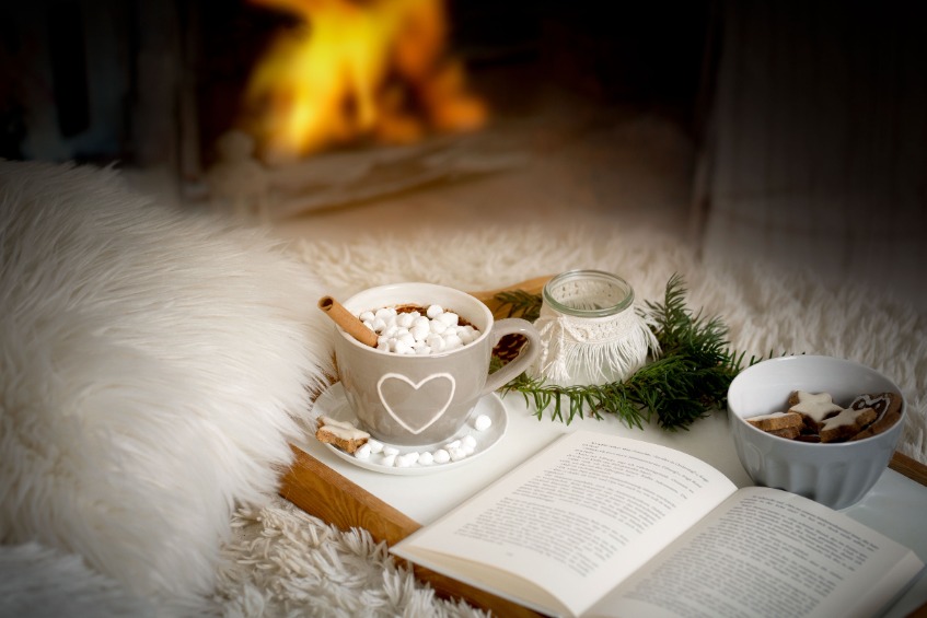 Karácsony idején, kandalló melegében könyv és karácsonyi édességek